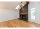 Bright living room features hardwood floors, a skylight, and a striking brick fireplace with a rustic wood beam at 12290 Charing Cross Rd, Carmel, IN 46033