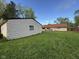 Home's backyard features green grass and a detached garage. Single story home sits behind it at 128 Coronado Rd, Indianapolis, IN 46234