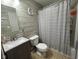The bathroom features a toilet, sink, vanity, and shower with a gray striped shower curtain at 128 Coronado Rd, Indianapolis, IN 46234