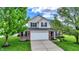 Charming two-story home with well-manicured landscaping, attached two-car garage, and classic brick and siding exterior at 13209 Westwood Ln, Fishers, IN 46038