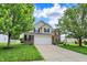 Traditional two-story home with brick and siding exterior and a spacious driveway at 13209 Westwood Ln, Fishers, IN 46038