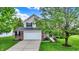 Charming two-story home with well-manicured landscaping, attached two-car garage, and classic brick and siding exterior at 13209 Westwood Ln, Fishers, IN 46038