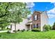 This two-story home is framed with mature landscaping and a mix of siding and brick at 13209 Westwood Ln, Fishers, IN 46038