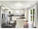 Well-lit kitchen with stainless steel appliances, center island, and sliding glass doors to outside at 13209 Westwood Ln, Fishers, IN 46038