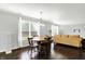 Open living room with wood floors, table, and large windows for ample natural light at 13209 Westwood Ln, Fishers, IN 46038