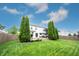 A backyard with a wooden deck, well-manicured lawn, mature trees, and a privacy fence at 14030 Avalon East Dr, Fishers, IN 46037