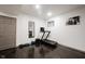 Basement workout area featuring a modern treadmill, a mirror, and ample natural light from the window at 14030 Avalon East Dr, Fishers, IN 46037