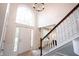 Inviting foyer with high ceilings, a staircase with wood railings, and a view of the front door at 14030 Avalon East Dr, Fishers, IN 46037