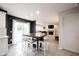Bright kitchen with modern appliances, dark accent wall, and wooden table with padded chairs overlooking the living room at 14030 Avalon East Dr, Fishers, IN 46037