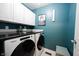 Functional laundry room with modern washer, dryer, storage cabinets, and granite countertops at 14030 Avalon East Dr, Fishers, IN 46037