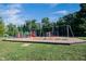 Community playground with swings, slides, climbing structures, and a soft landing surface, surrounded by mature trees at 14030 Avalon East Dr, Fishers, IN 46037