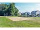 Sand volleyball court on a grassy field with a net, and houses in the background under a clear blue sky at 14030 Avalon East Dr, Fishers, IN 46037