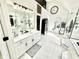 A bright primary bathroom boasts sleek white cabinets, marble floors, and high-end fixtures at 14035 Stone Key Way, Fishers, IN 46037