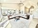 Spacious living room with vaulted ceilings, modern chandelier, and a large sectional, open to kitchen and dining area at 14035 Stone Key Way, Fishers, IN 46037