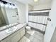 Well-lit bathroom featuring a shower with stylish black and white curtain and a white vanity at 14035 Stone Key Way, Fishers, IN 46040