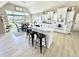 Spacious kitchen boasts white cabinets, modern appliances, and a breakfast bar with seating, all with views of the dining area at 14035 Stone Key Way, Fishers, IN 46040