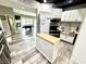 Open basement kitchenette with stainless steel appliances and island next to recreation area at 14035 Stone Key Way, Fishers, IN 46040