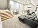 Inviting living room with a plush gray sofa, large screen, and unique stairs leading to elevated seating area at 14035 Stone Key Way, Fishers, IN 46040
