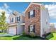 Modern two-story home with gray vinyl and red brick exterior complemented by green lawn and landscaping at 1452 Bigleaf Dr, Sheridan, IN 46069