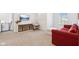A bright living room features a comfortable red couch, TV, and large windows for natural light at 1452 Bigleaf Dr, Sheridan, IN 46069