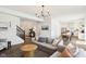 Spacious living room with hardwood floors, a cozy sofa, and an open layout leading to the kitchen and dining area at 1452 Bigleaf Dr, Sheridan, IN 46069