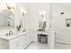 Bright and airy bathroom with double vanity sinks, elegant sconces, and a separate shower area at 14728 Adios Pass, Carmel, IN 46032