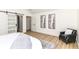 Bright bedroom with a modern sliding barn door, sleek wood flooring, and contemporary artwork at 14728 Adios Pass, Carmel, IN 46032
