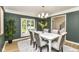 Formal dining room featuring elegant gray walls, contemporary chandelier, view into an adjacent living space, and outdoor view at 14728 Adios Pass, Carmel, IN 46032
