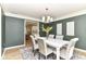 Formal dining room featuring elegant gray walls, contemporary chandelier, and view into an adjacent living space at 14728 Adios Pass, Carmel, IN 46032