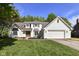 Charming two-story home with a well-manicured lawn, attached garage, and a welcoming, wooden front door at 14728 Adios Pass, Carmel, IN 46032