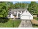 Charming two-story home with a well-manicured lawn, attached garage, and a welcoming, wooden front door at 14728 Adios Pass, Carmel, IN 46032