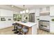 Stylish kitchen featuring a quartz island, stainless appliances, breakfast bar seating, and patio access at 14728 Adios Pass, Carmel, IN 46032