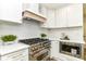 Close-up of kitchen featuring stainless steel appliances, white cabinets, and subway tile backsplash at 14728 Adios Pass, Carmel, IN 46032