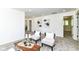Bright living room boasts neutral decor and two comfy armchairs on soft gray carpet at 14728 Adios Pass, Carmel, IN 46032