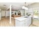 Open concept kitchen and living room with fireplace, leather sofa, and quartz waterfall island at 14728 Adios Pass, Carmel, IN 46032