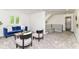 Bright living area with a comfortable blue sofa, chic chairs, and staircase access, illuminated by natural light at 14728 Adios Pass, Carmel, IN 46032
