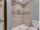 Modern shower with a tiled wall, built-in shelves, a handheld shower head, and a white shower base for a luxurious experience at 1476 Anon Ct, Greenwood, IN 46143