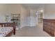 Bright bedroom featuring neutral carpet, a toddler bed, a storage shelf with toys, and an open doorway leading to another room at 1476 Anon Ct, Greenwood, IN 46143