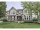 Charming two-story home featuring a stone facade, well-manicured lawn, and inviting front porch at 1476 Anon Ct, Greenwood, IN 46143
