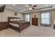 Spacious main bedroom featuring tray ceilings, carpet flooring, a ceiling fan, and large windows with sheers at 1476 Anon Ct, Greenwood, IN 46143