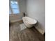 Modern bathroom showcasing a sleek white bathtub with wooden-look tile floor and natural light at 1512 Bellefontaine St, Indianapolis, IN 46202