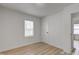 Bedroom featuring wood-look floors, one window with blinds, and a white door at 1517 Wallace Ave, Indianapolis, IN 46201