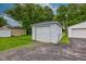 A detached one car garage has a traditional door with painted wood siding and black asphalt driveway at 1517 Wallace Ave, Indianapolis, IN 46201