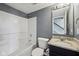 Cozy bathroom featuring a white shower-tub combo, toilet, and granite sink vanity with square mirror at 15369 Mystic Rock Dr, Carmel, IN 46033