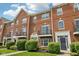 Beautiful red brick townhouse exterior with black iron balconies and manicured green landscaping at 15369 Mystic Rock Dr, Carmel, IN 46033