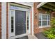 Elegant front door with sidelights and decorative trim on a red brick home at 15369 Mystic Rock Dr, Carmel, IN 46033