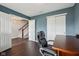 Home office features a dark wood desk, rolling black office chair, and view of the staircase at 15369 Mystic Rock Dr, Carmel, IN 46033