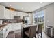 Bright kitchen with white cabinets, granite counters, stainless appliances, and an island with seating and outdoor view at 15369 Mystic Rock Dr, Carmel, IN 46033
