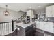 Open-concept kitchen featuring a central island with seating, granite counters and easy access to the staircase at 15369 Mystic Rock Dr, Carmel, IN 46033