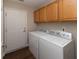 Functional laundry room equipped with a washer, dryer, and wood cabinets at 16628 Brownstone Ct, Westfield, IN 46074